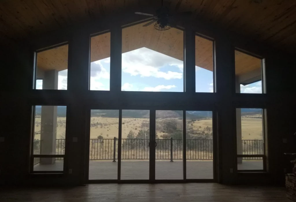 wooden house with tall ceilings large windows and views of the southern Colorado mountains